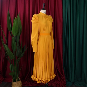 Detailed view of ginger yellow puff sleeve top and pleated skirt with ruffles