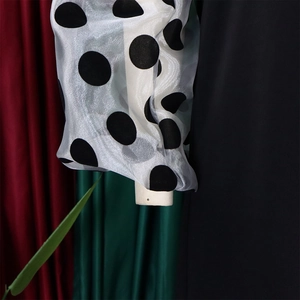 Detail von transparenten Puffärmeln mit schwarzen Punkten auf einem Netz-Patchwork-Kleid