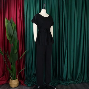 Vue détaillée d'un ensemble deux pièces noir avec haut ceinturé et pantalon large