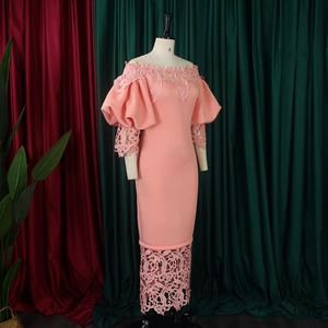 Detail of coral pink off-shoulder dress featuring intricate floral lace and puff sleeves