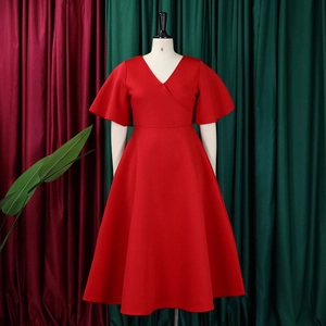 Detail of red V-neck dress with flare sleeves and A-line silhouette on a mannequin