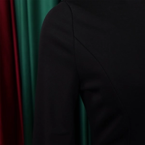 Detailed close-up of premium fabric texture and precise shoulder stitching on a black dress
