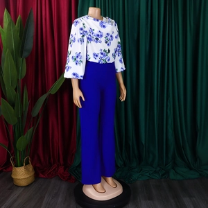 Détail du haut à fleurs blanches et roses bleues avec pantalon évasé à taille haute