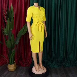 Detail of yellow V-neck pencil dress with waist belt and metal eyelet accents