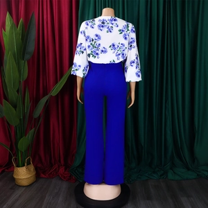 Vue arrière du haut élégant à fleurs et du pantalon bleu large pour femmes