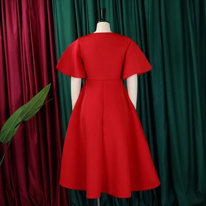 Detail view of the back of a red V-neck dress featuring flared sleeves and a high waist