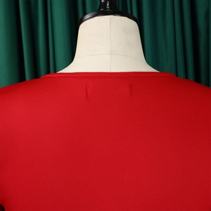 Detail of red dress neckline showing precise stitching and smooth knit fabric texture