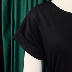 Détail de la manche à revers et du tissu de qualité sur ce haut noir à col rond