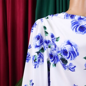Détail de l'imprimé floral rose bleue sur haut en satin blanc avec épaules plissées