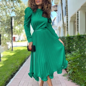 Close-up of emerald green satin long sleeves and pleated skirt texture of the set