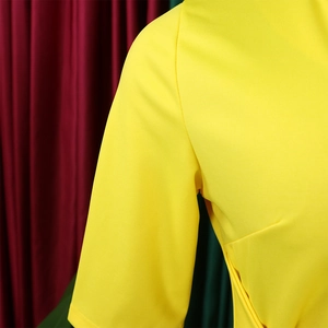 Detailed view of the shoulder stitching and sleeve cut on an elegant yellow V-neck dress
