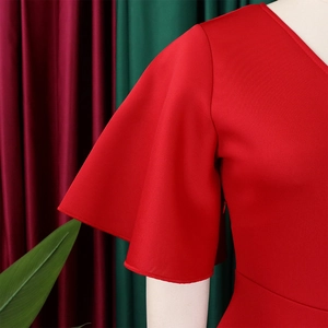 Close-up of elegant red V-neck dress with layered ruffle sleeves on a mannequin