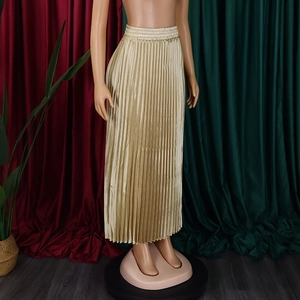 Détail d'une jupe longue plissée dorée avec texture satinée et taille haute élastique