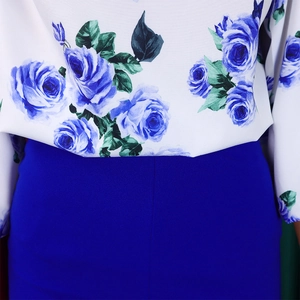 Détail de l'imprimé roses bleues sur haut blanc avec couture de taille en tissu bleu roi