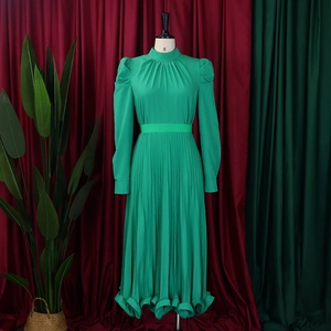 Detail of puff sleeves and pleated waist on a vibrant lime green long sleeve midi dress