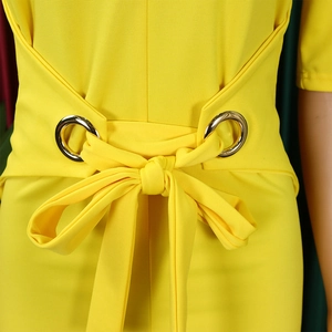 Detail of yellow pencil dress waist with silver metal rings and bow tie belt decoration