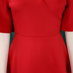 Detailed close-up of V-neck crossover design and waist seam on a red evening dress
