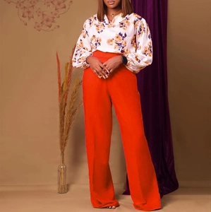 Détail du pantalon large à taille haute associé à un chemisier fleuri à manches longues