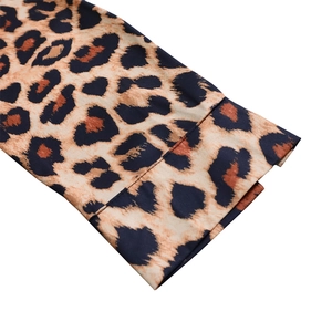 Dettaglio macro del polsino in raso con stampa leopardata e cuciture di precisione