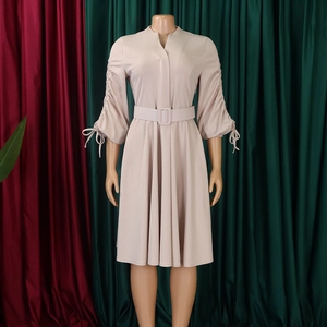 Détail d'une robe beige élégante avec manches plissées et nœuds à cordon réglable
