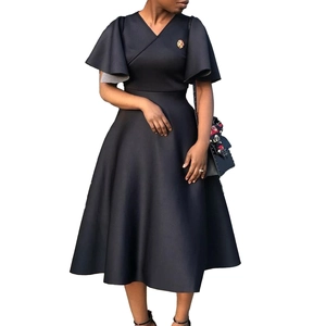 Detail of elegant black V-neck dress featuring layered ruffle sleeves and golden brooch