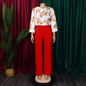 Détail du haut à manches longues avec imprimé rose et pantalon évasé rouge en ensemble