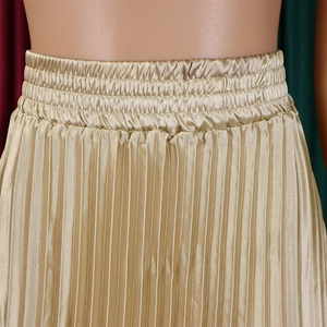 Détail d'une jupe longue plissée or champagne avec taille élastique et texture satinée