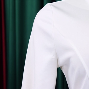 Detail of clean stitching and high-quality white fabric texture on a long sleeve dress