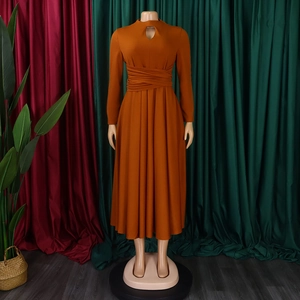 Detail of caramel pleated dress featuring a high neckline and teardrop cutout design