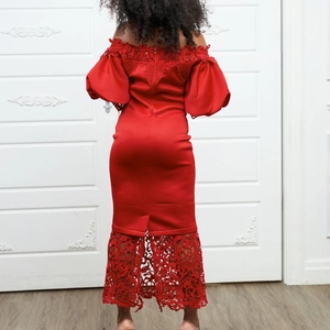 Detail of the back of a red satin gown showing lace hem and puff sleeves for party