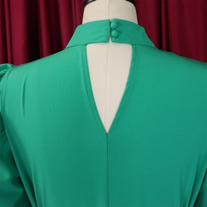 Close-up of vibrant green top with high neck halter design and back cutout detail