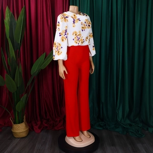 Détail du haut à fleurs en mousseline et du pantalon rouge taille haute à jambes larges