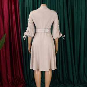 Détail du dos d'une robe beige à manches longues avec ceinture et manches lanternes