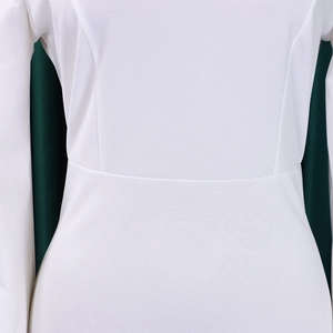 Detail view of white dress with premium knit fabric texture and elegant waist stitching