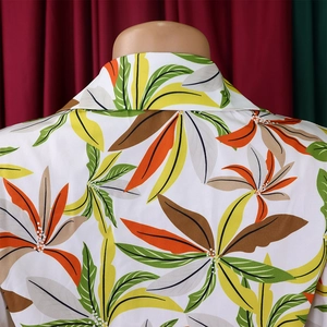 Close-up of the shirt's classic lapel collar with vibrant tropical leaf print detail