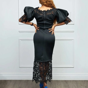 Detailed back view of a slim black dress featuring lantern sleeves and floral lace trim
