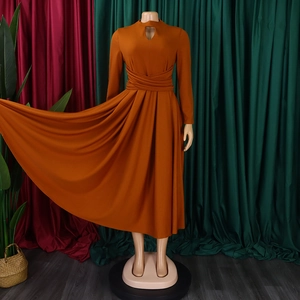 Detail of elegant caramel dress with pleated waist and teardrop cutout neckline