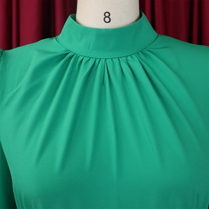 Detail of emerald green high neck chiffon top with pleated collar and elegant drapes