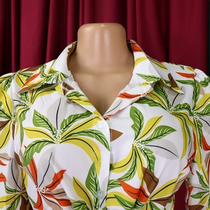 Close-up of tropical leaf print shirt with white buttons and elegant turnover collar