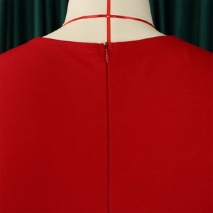 Detail of a red V-neck dress showing the back invisible zipper and woven fabric texture