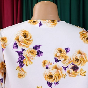 Gros plan détaillé de l'imprimé rose jaune sur un tissu léger blanc pour femme