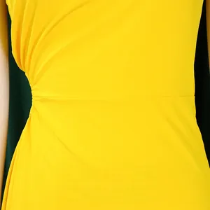 Detail of ruched waist design on a yellow one-shoulder dress with soft knit texture