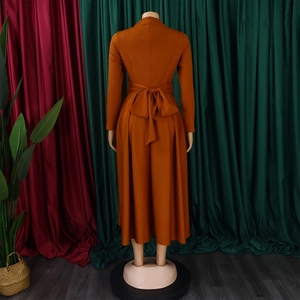 Rear view of an amber long-sleeve maxi dress with a waist bow tie and high neck collar