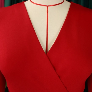 Detail view of red dress deep V-neckline with high quality fabric texture on mannequin