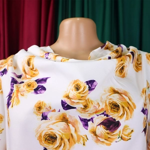 Détail du tissu en mousseline blanche avec imprimé de roses jaunes et texture