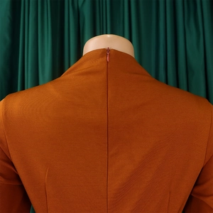 Detailed back view of pleated orange dress featuring a seamless invisible zipper closure