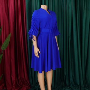 Détail d'une robe bleu roi à col en V avec manches plissées et ceinture assortie