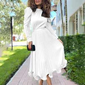 Detail of white bubble sleeve top and pleated maxi skirt set for women with black clutch
