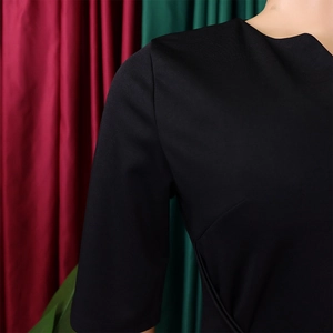 Detail of elegant black V-neck dress with premium structured fabric and clean shoulder lines