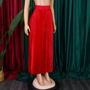 Détail d'une jupe longue plissée rouge avec taille haute élastique et texture satinée